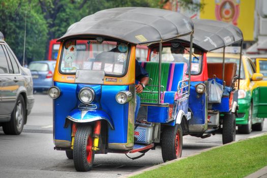 Tuc-Tucs in a Bangkok street awaiting customers