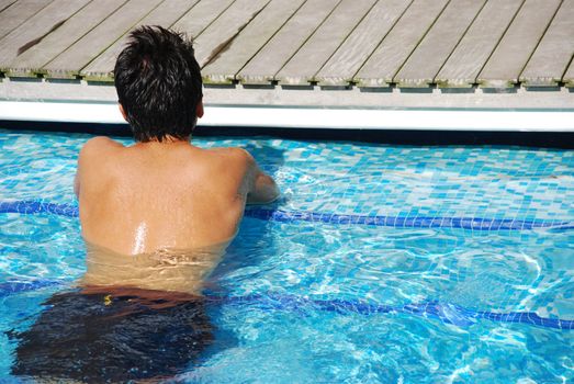 handsome man relaxing at the swimming pool