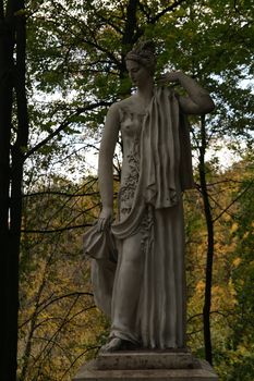 Ancient female statue in autumn park in full-length