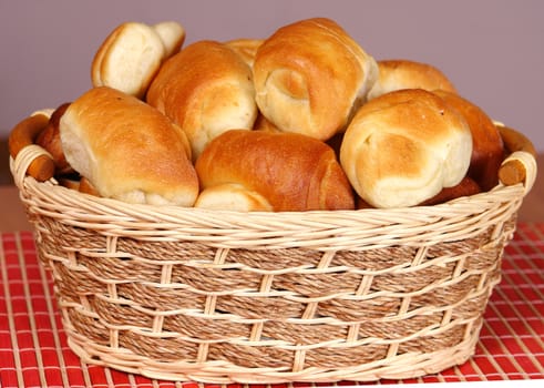 A basket with fresh baked bun and croissants.                               
