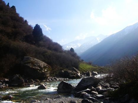 noise of roaring rivers, gnashing reverberating under the powerful stream of stones and rocks rolled down the slopes, piercing the air, cold wind, snow-white peaks, it is all mountains of the Tien-Shan