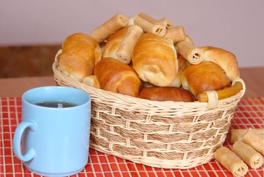 A basket with fresh baked bun and croissants.                                