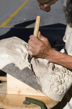 Craftsman carving a face in the wood