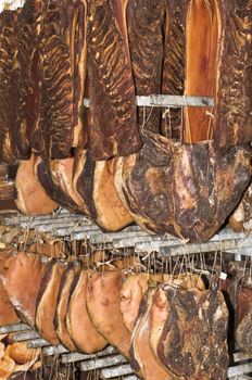 Hanged speck (salted and smocked ham) pieces drying up in a maturing storeroom.