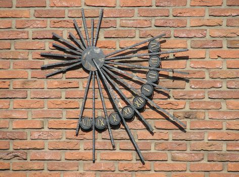 metal sundial on a brick wall