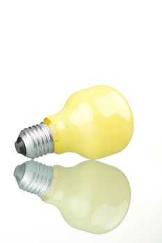 Yellow bulb with reflection, isolated on white background.