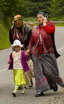 Two ethnic woman with child walking on the road to Rize in East Turkey near the border with Georgia. 