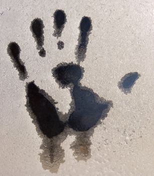 Handprint melted on to a frosted window