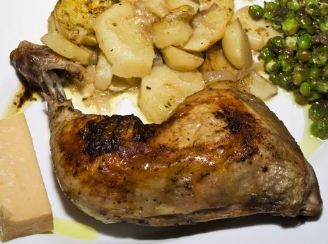 Roast chicken leg and potatoes and peas