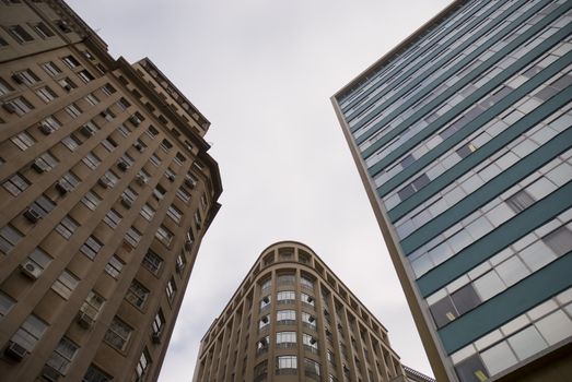 Office building seen from below, with blue sky with some clouds.