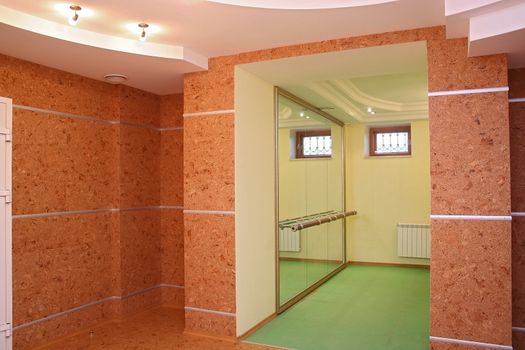 Empty room with a parquet floor, a portal in the next room, a fireplace and a window

