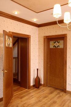 Room without furniture with a parquet floor and two wooden doors