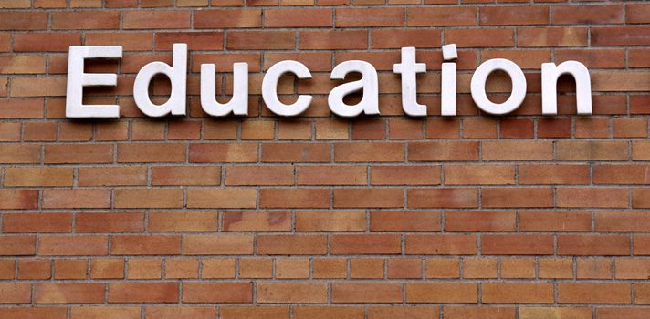 The word education on a brick wall.