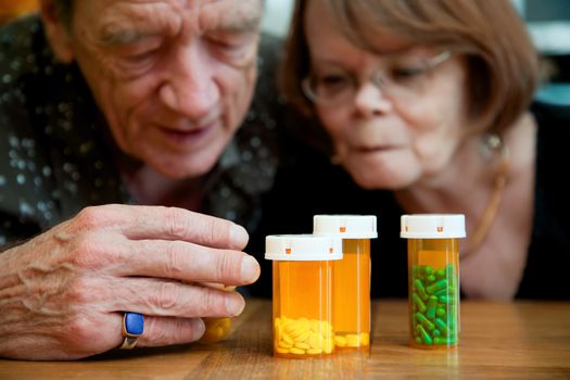Man and woman closely examing instructions on prescription medications
