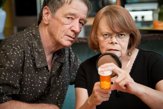 Senior couple closely examining instructions on prescription medications