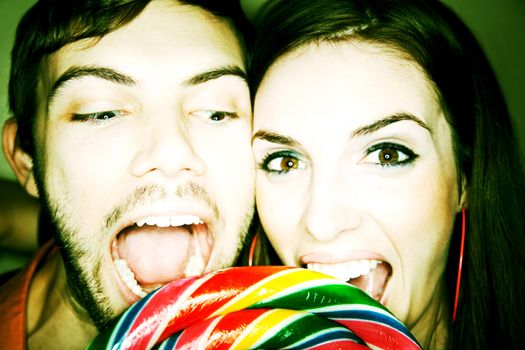 Cute Couple Biting into Big Colorful Lollipop