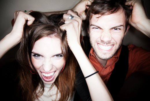 Crazy young couple pulling on their own hair