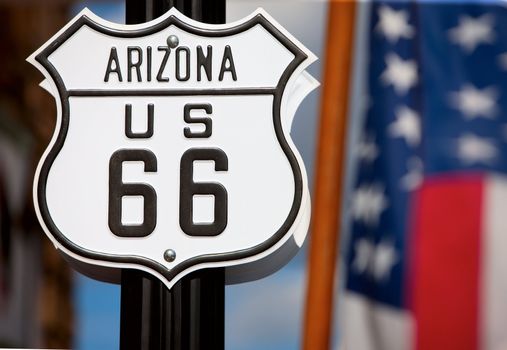 Route 66 sign on side of road with American flag