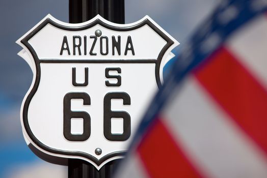 Route 66 sign on side of road with American flag