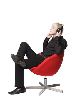 Man siting in armchair listens to music