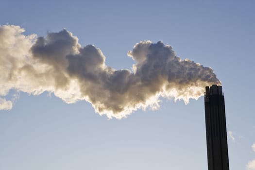 Smoking chimney against a blue sky