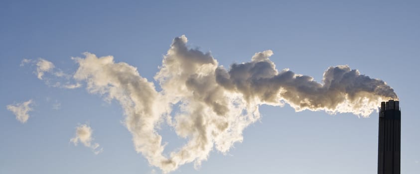 Smoking chimney against a blue sky