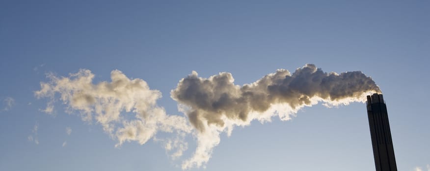 Smoking chimney against a blue sky