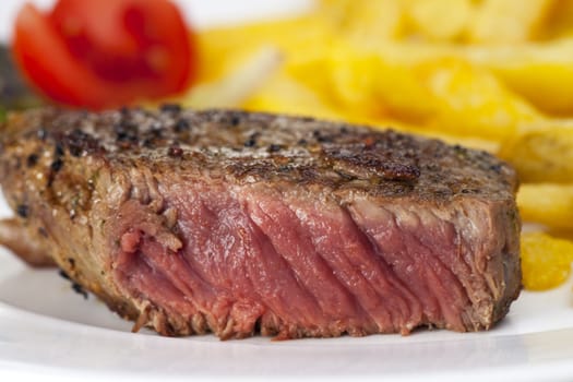 closeup of a beef steak with french fries on a white background