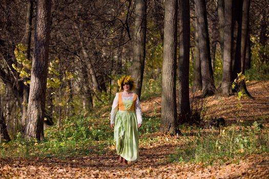 Woman in medieval dress in autumn forest
