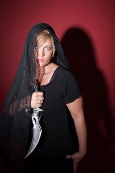 Caucasian woman in black veil with Athame
