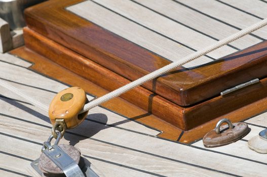 Detail of block and rope on a deck of a wooden sailboat