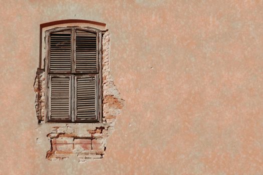 Urban decay photograph showing old window with blinds and bricks behind ruined facade. Plenty of space for your text on the right half of photo.