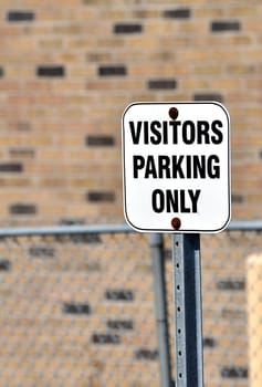 View of a visitors parking only sign.