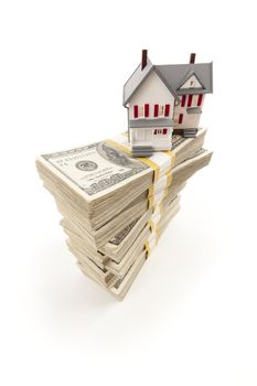 Small House on Stacks of Hundred Dollar Bills Isolated on a White Background.