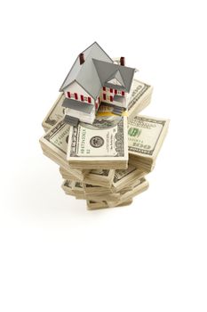 Small House on Stacks of Hundred Dollar Bills Isolated on a White Background.