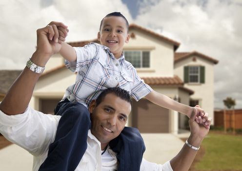 Playful Hispanic Father and Son in Front of Beautiful House.