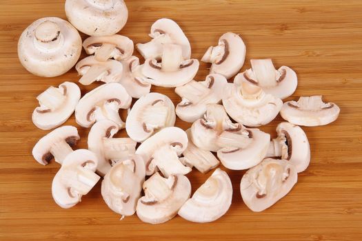 mushrooms to cut on brown chopping board                               