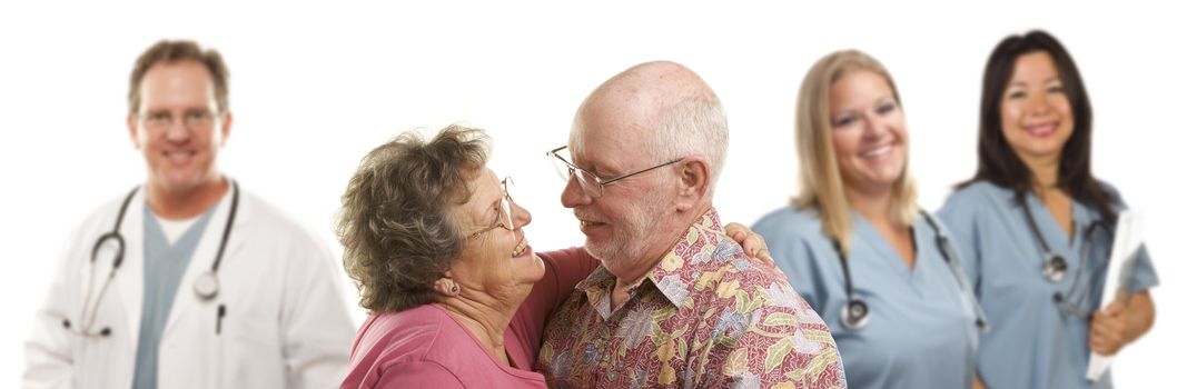 Happy Loving Senior Couple with Smiling Medical Doctors or Nurses Behind Isolated on a White Background.