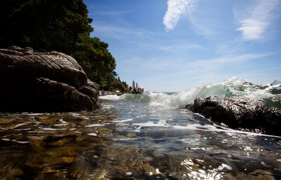 A wave splashes against rocks on the croatian coast