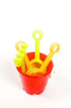 Red bucket and toys, isolated on white background