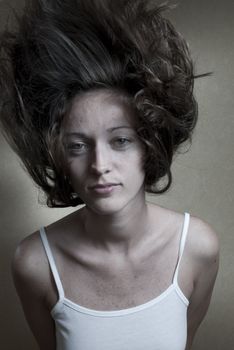 Studio portrait of young woman with hair floating in the air.