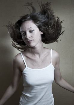Studio portrait of young woman with hair floating in the air.