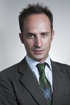 Headshot of white man in a suit with neutral gray background.
