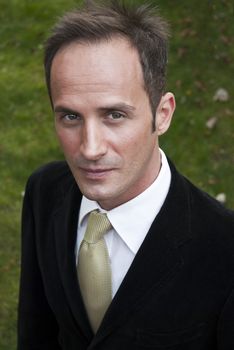 High angle headshot of white man in a black suit looking up slightly.