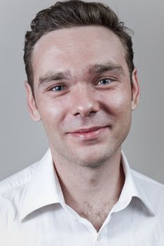 Headshot of young white man with neutral gray background.