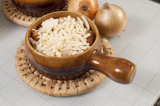 Arrangement of two bowls of onion soup and fresh onions