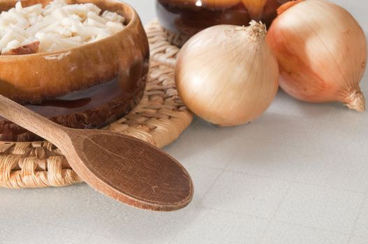 Arrangement of two bowls of onion soup and fresh onions