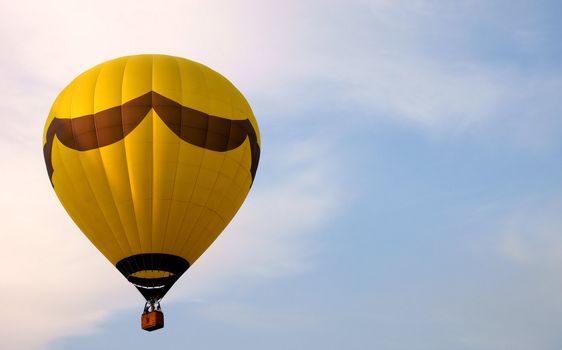 Yellow hot air balloon against a blue sky