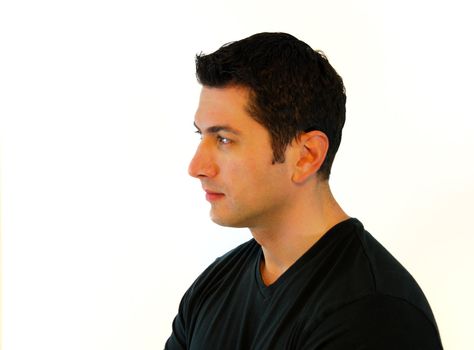 A profile of a pensive man in black t-shirt over white background.