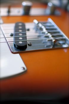 An electric guitar shines in the light of a nearby window.